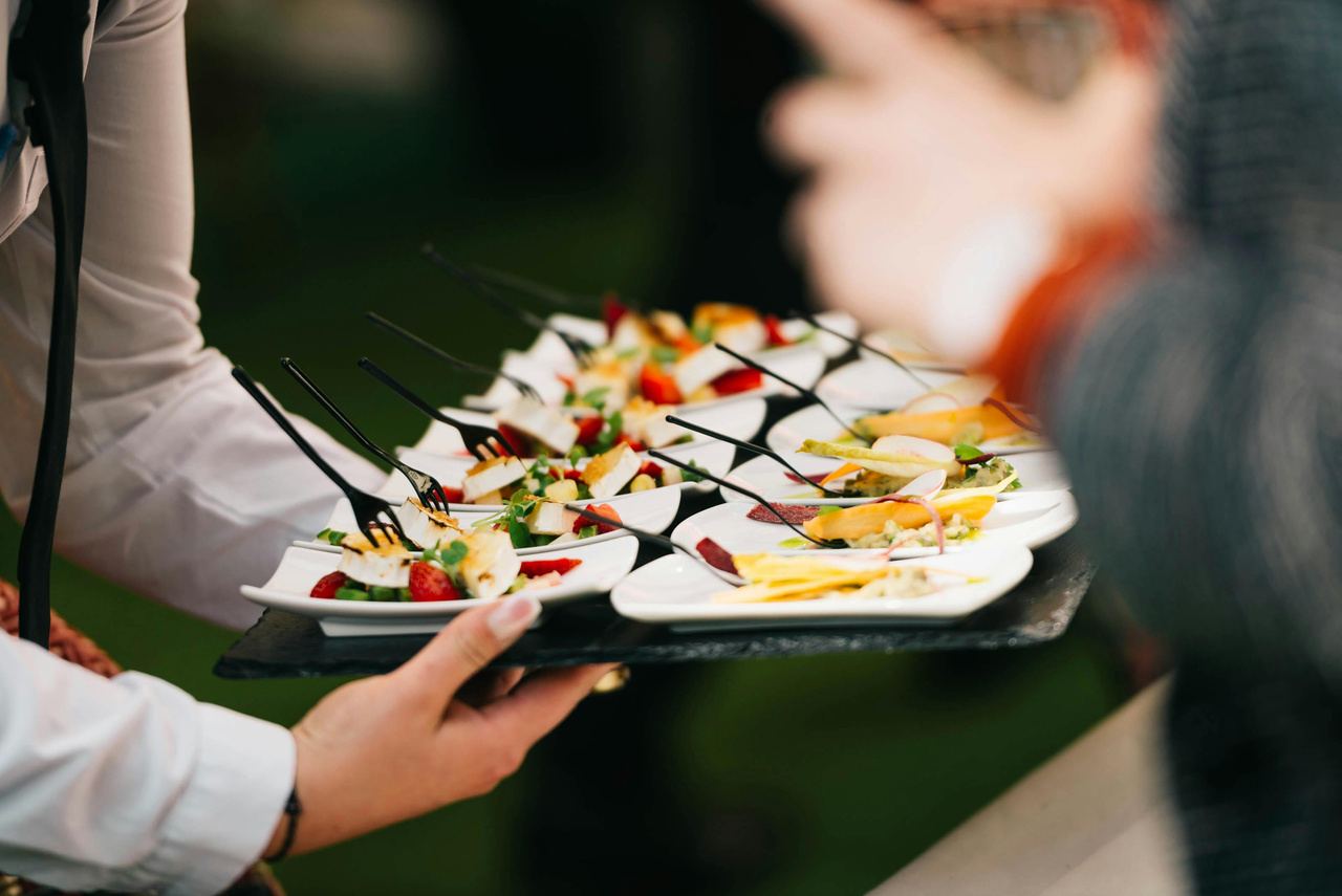 A server carrying a tray of plated canapés